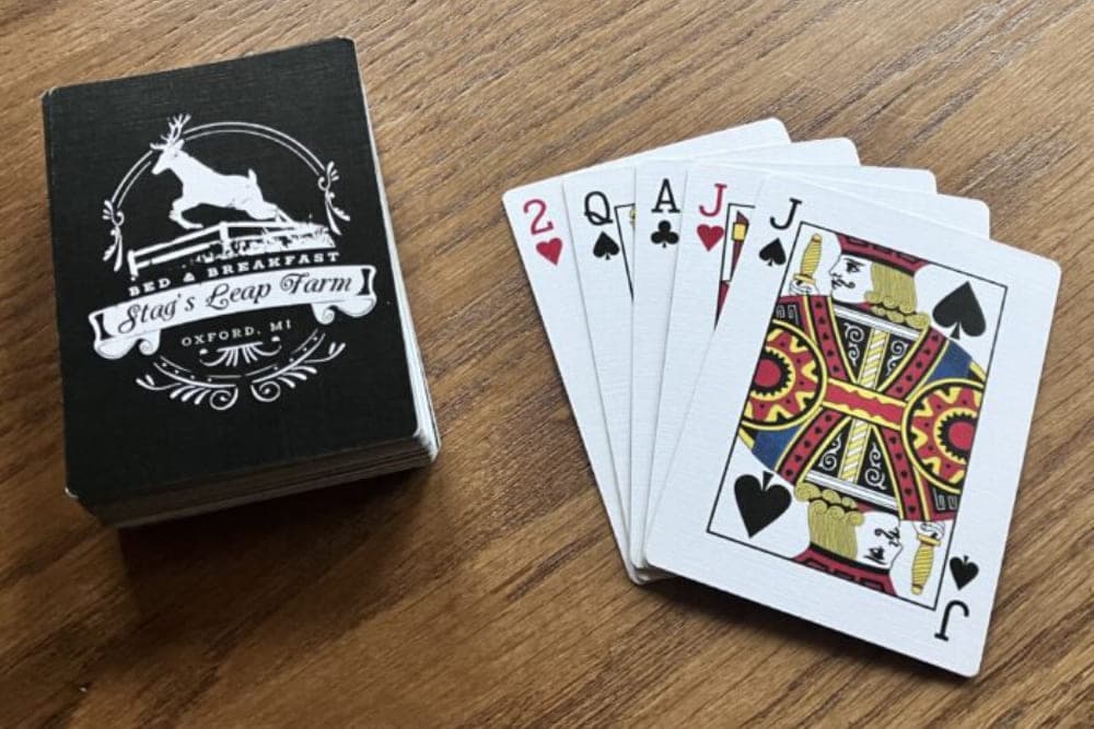 A deck of playing cards next to a box labeled "Stag's Leap Farm Bed & Breakfast, Oxford, MI."